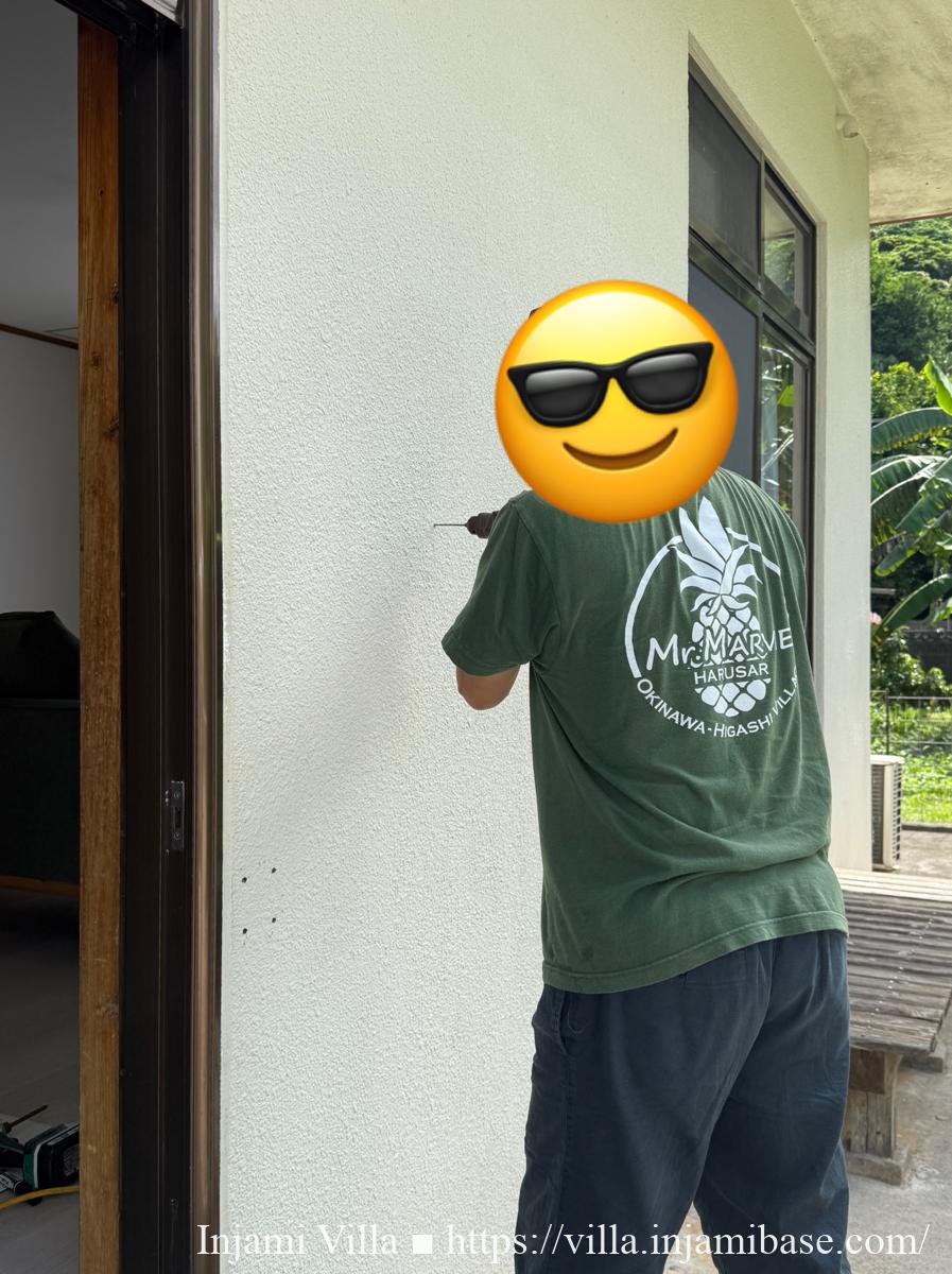 コンクリート壁にポストを取り付けている作業の様子